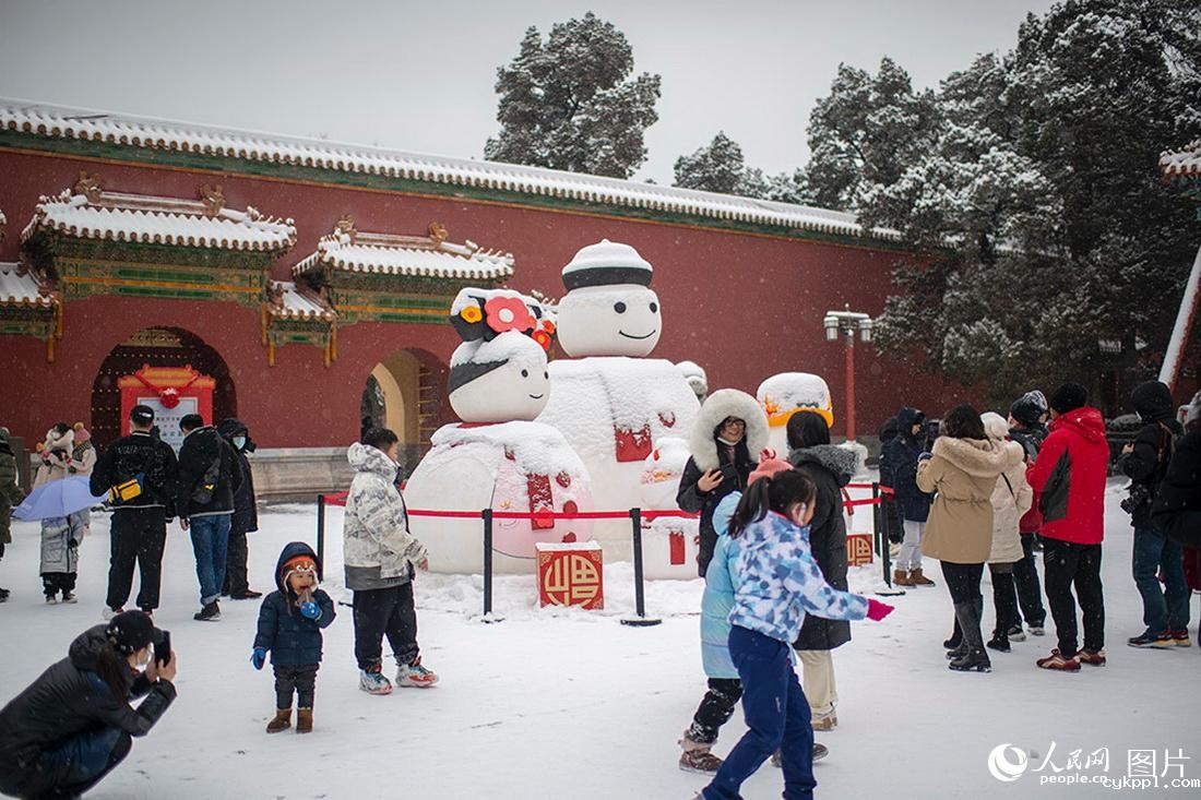 2月13日，在北京景山公园，游客尽享降雪带来的欢乐。人民网记者翁奇羽摄